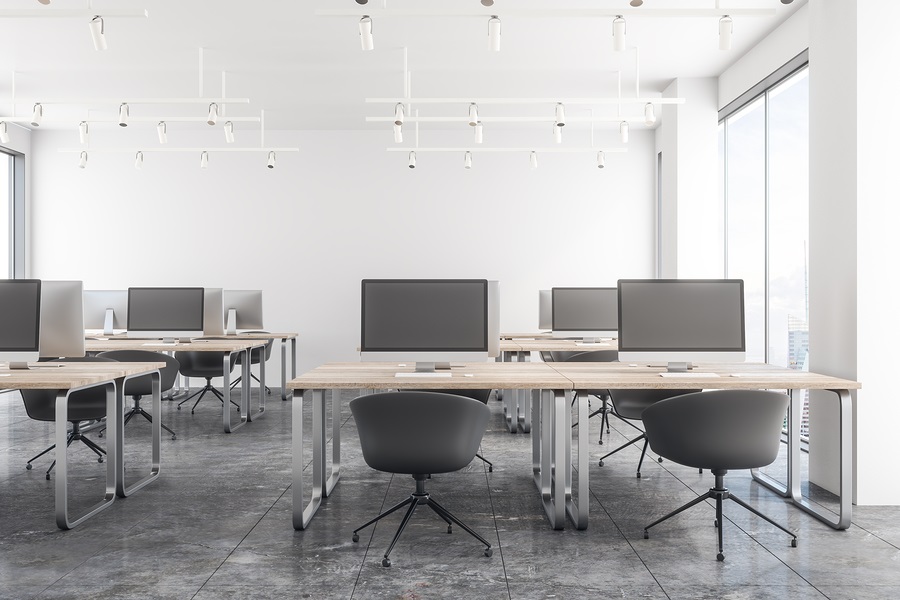 View of office with marble tiles, two columns of workstation desks, and two computer chairs at each desk.